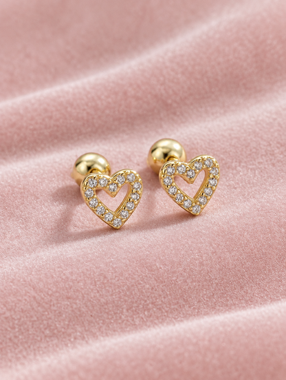 Gold open heart stud earrings lying flat on a soft styled surface
