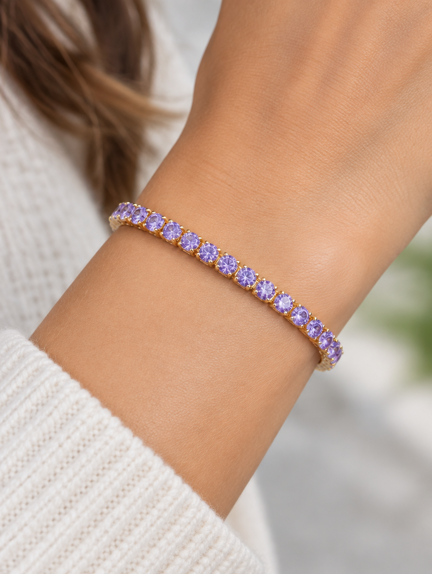 Woman wearing a gold tennis bracelet with purple zirconia stones