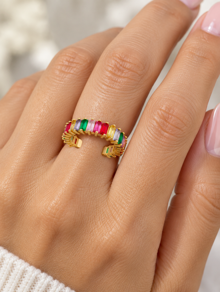 Woman wearing a gold rainbow baguette stone ring on her finger