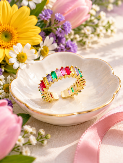 Gold rainbow baguette stone ring in a small dish with styling props