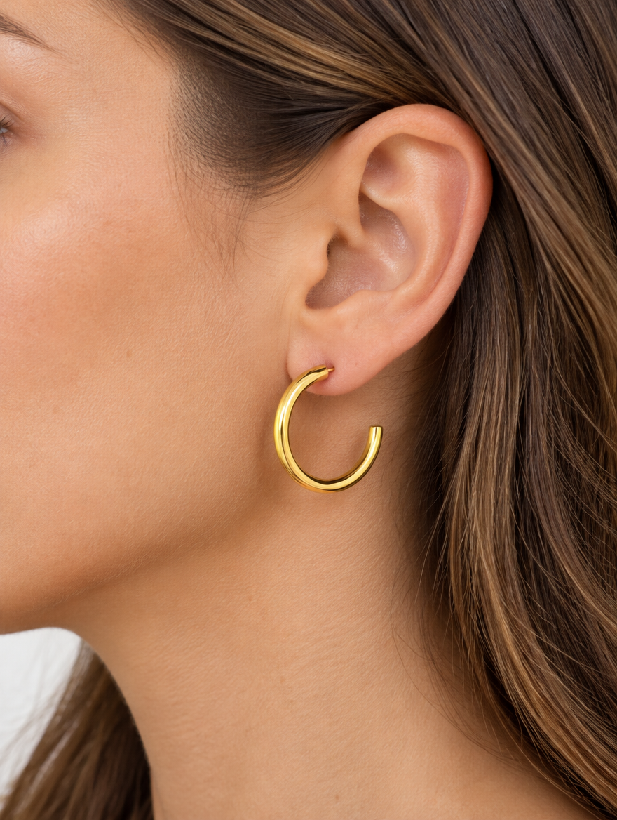 Woman wearing a gold open c-shape hoop earring