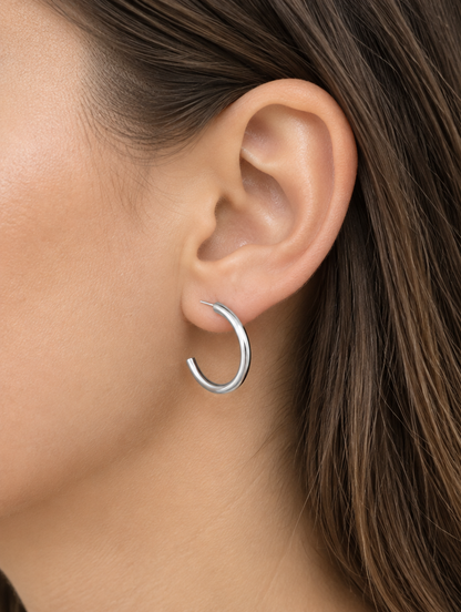 Woman wearing a silver open c-shape hoop earring