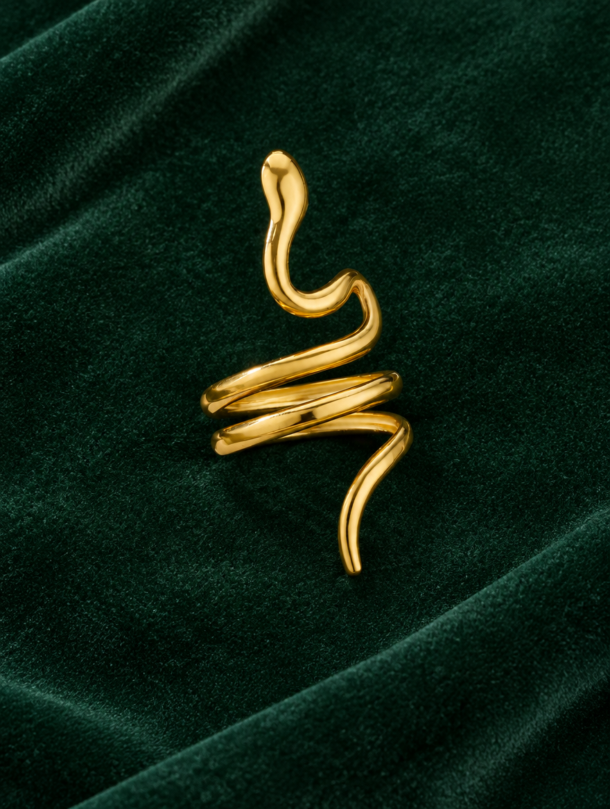 Gold snake coil ring resting on a soft textured surface