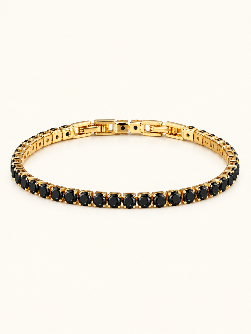 Gold tennis bracelet with black zirconia stones on a neutral background