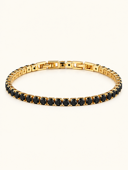 Gold tennis bracelet with black zirconia stones on a neutral background