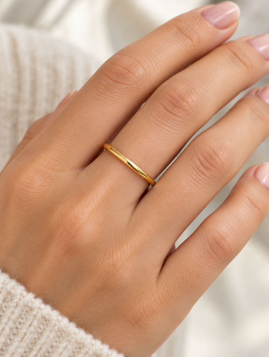 Woman wearing a thin gold polished band ring on her finger