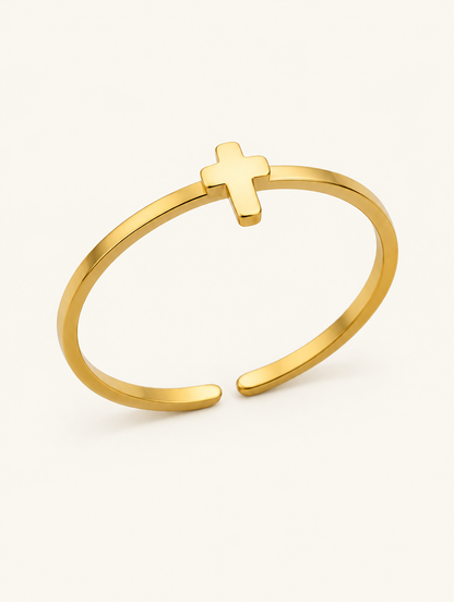Thin gold cross ring on a neutral background