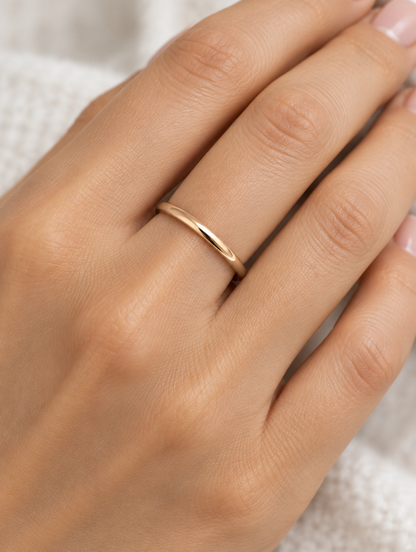 Woman wearing a thin rose gold polished band ring on her finger