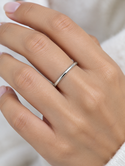 Woman wearing a thin silver polished band ring on her finger