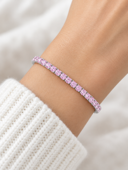 Woman wearing a silver tennis bracelet with pink zirconia stones