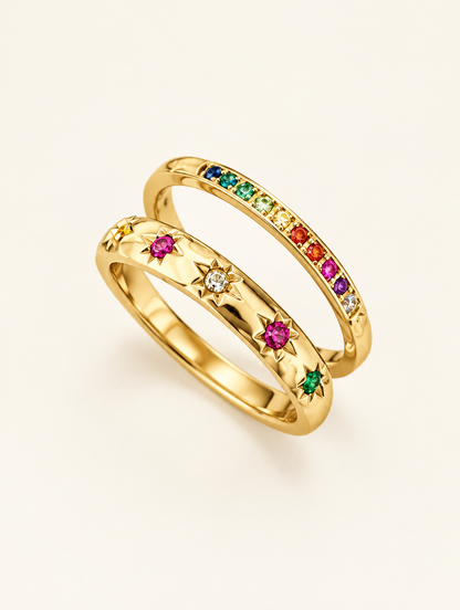 Set of two gold rainbow zirconia and star rings on a neutral background