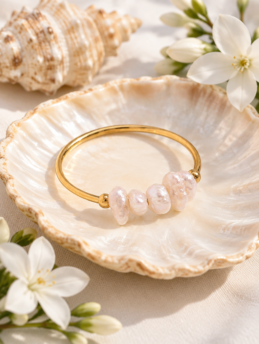 Gold freshwater pearl open ring in a small dish with styling props