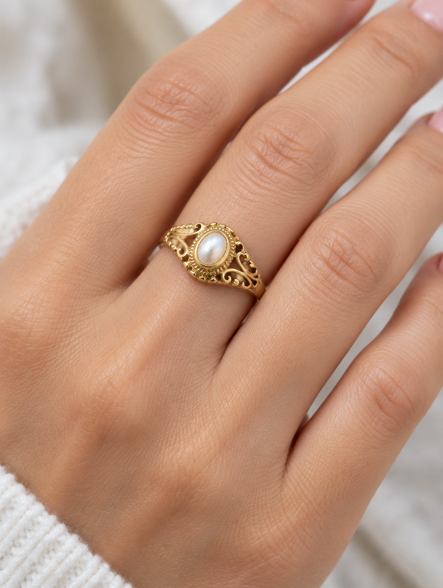 Woman wearing a gold vintage-style pearl ring on her finger
