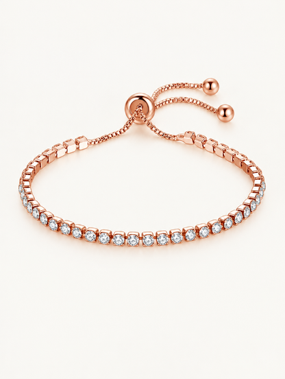 Rose gold slider tennis bracelet with clear zirconia stones on a neutral background