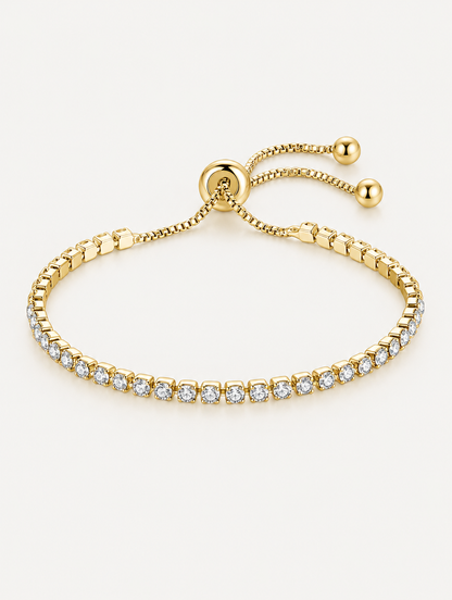 Gold slider tennis bracelet with clear zirconia stones on a neutral background