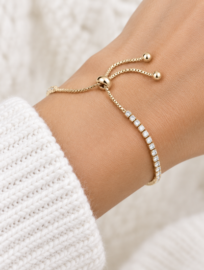 Woman wearing a gold slider tennis bracelet with clear zirconia stones