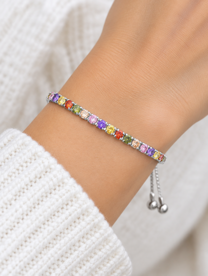 Woman wearing a silver slider bracelet with multicoloured zirconia stones