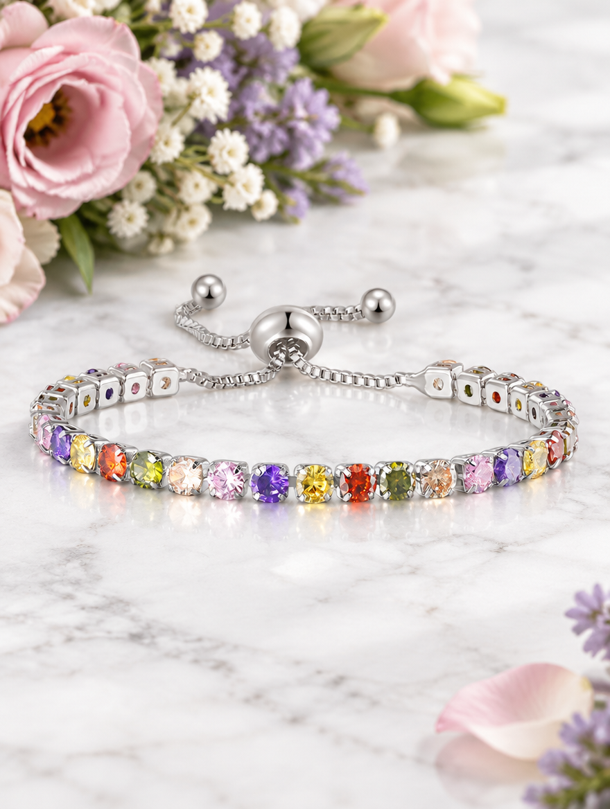 Silver rainbow zirconia bracelet beside pastel flowers on marble