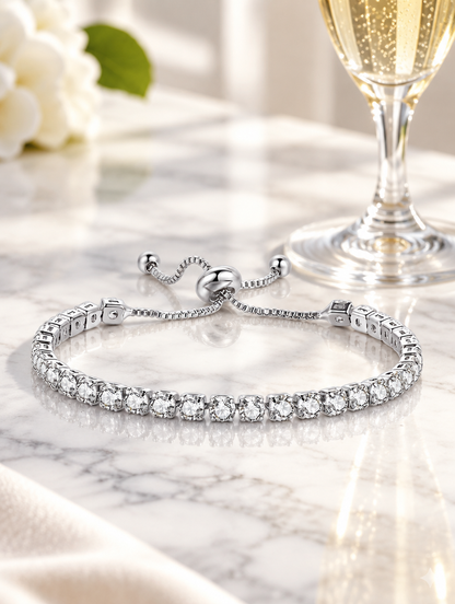 Silver zirconia bracelet beside a champagne flute on marble