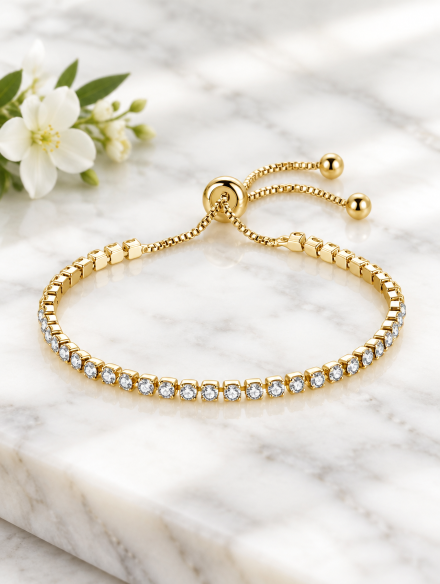 Gold zirconia bracelet beside a white flower on marble
