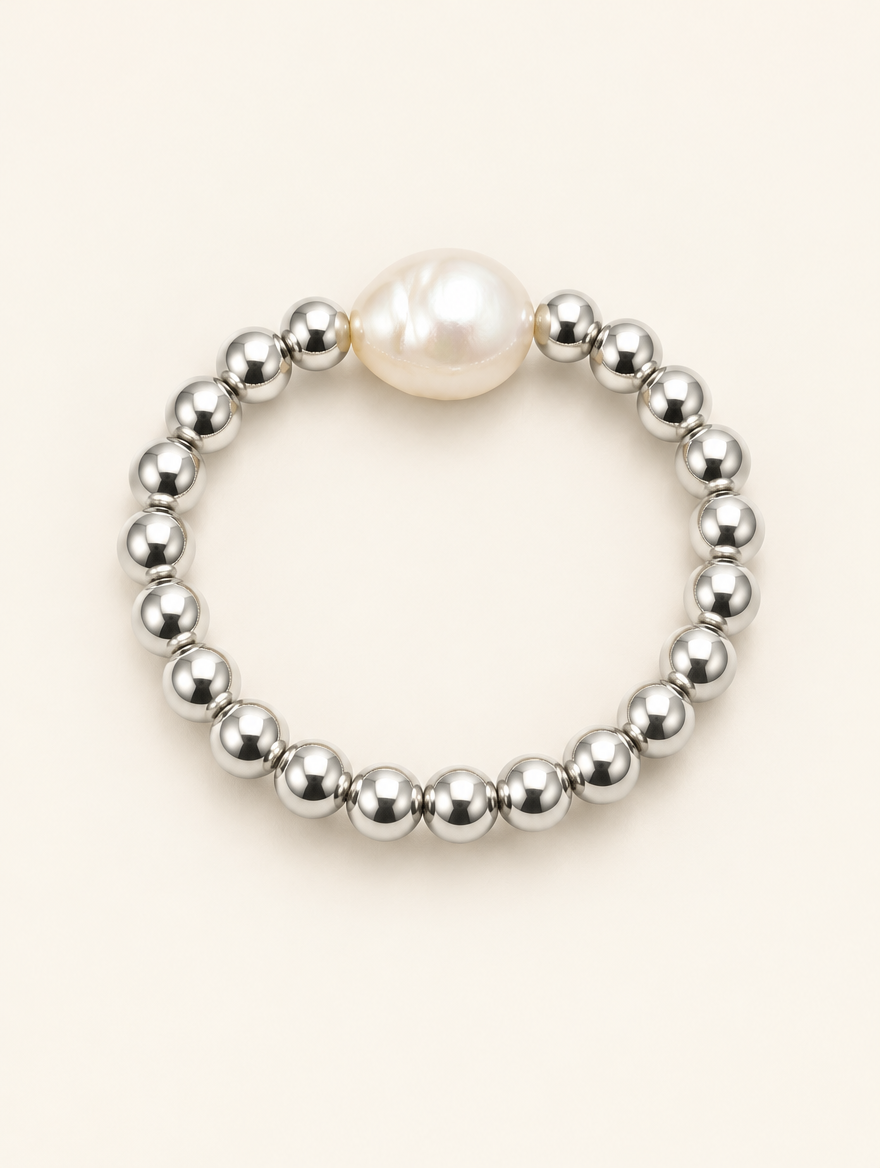 Silver bead ring with a baroque pearl on a neutral background