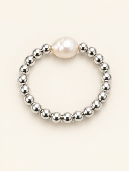 Silver bead ring with a baroque pearl on a neutral background