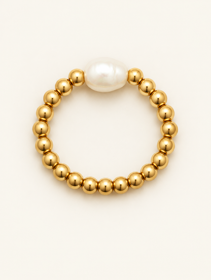 Gold bead ring with a baroque pearl on a neutral background