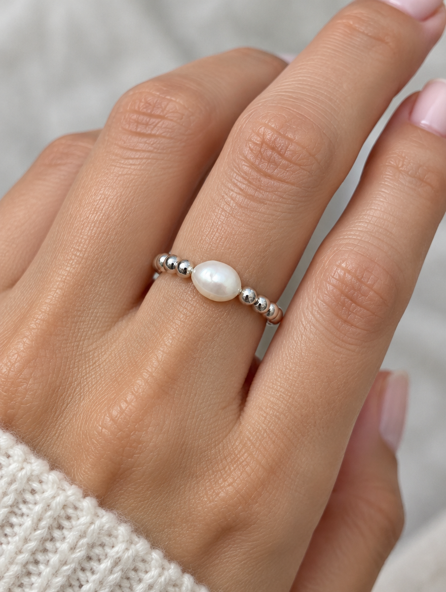 Woman wearing a silver bead ring with a baroque pearl on her finger