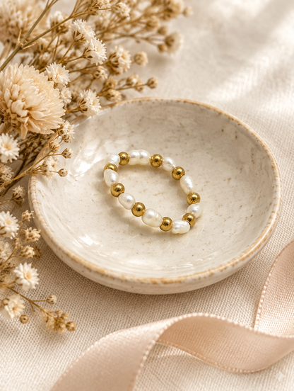 Gold bead ring with pearl accents in a small dish with styling props