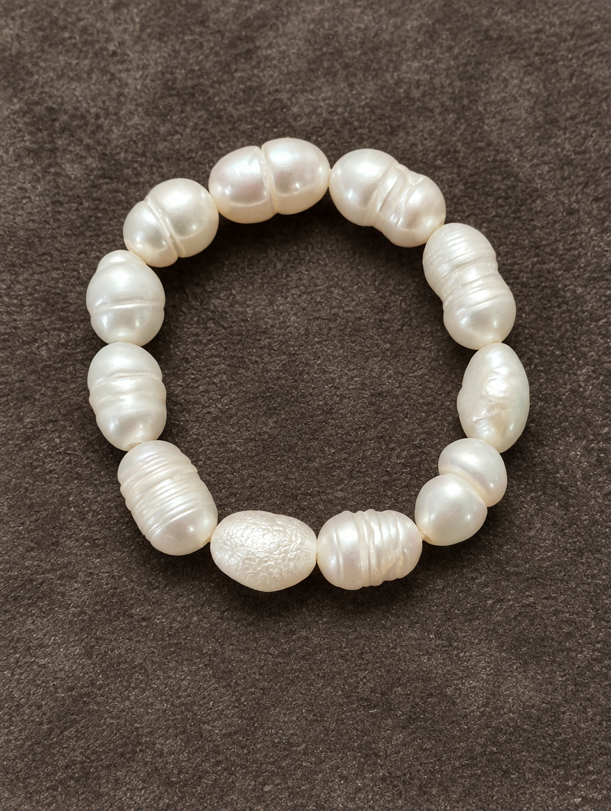 White baroque freshwater pearl beaded ring resting on a soft textured surface