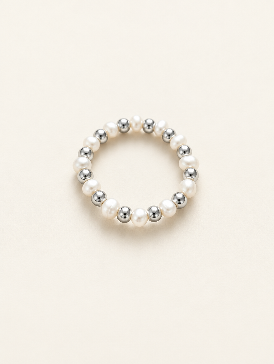 Silver mini bead ring with pearl accents on a neutral background