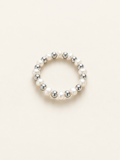 Silver mini bead ring with pearl accents on a neutral background