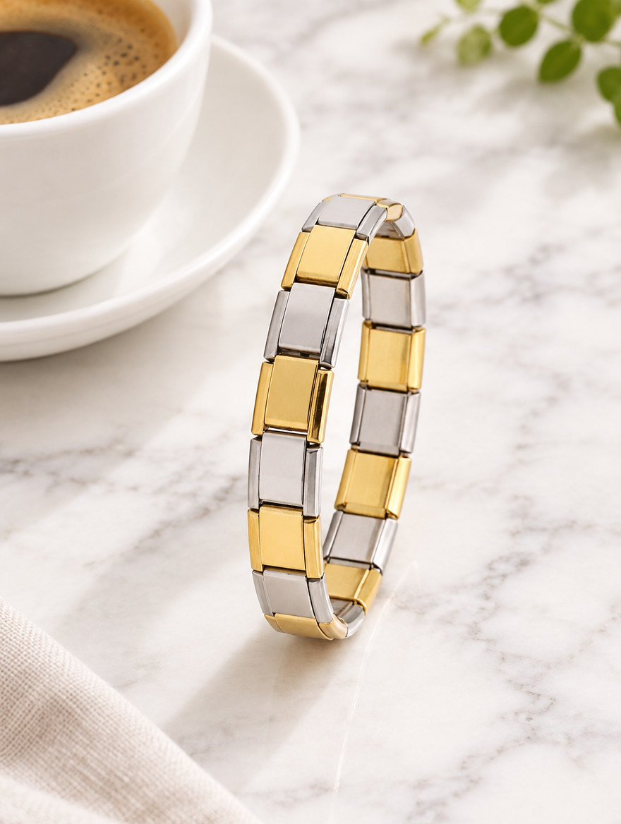 Two-tone link bracelet beside a coffee cup on marble