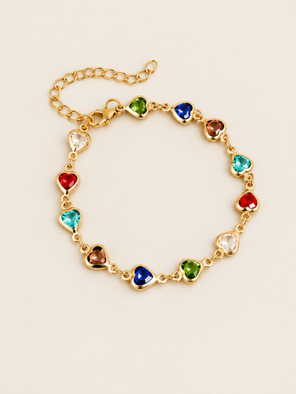 Gold-tone chain bracelet with multicolour crystal hearts on a neutral background