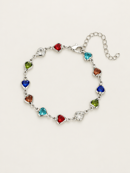 Silver-tone chain bracelet with multicolour crystal hearts on a neutral background