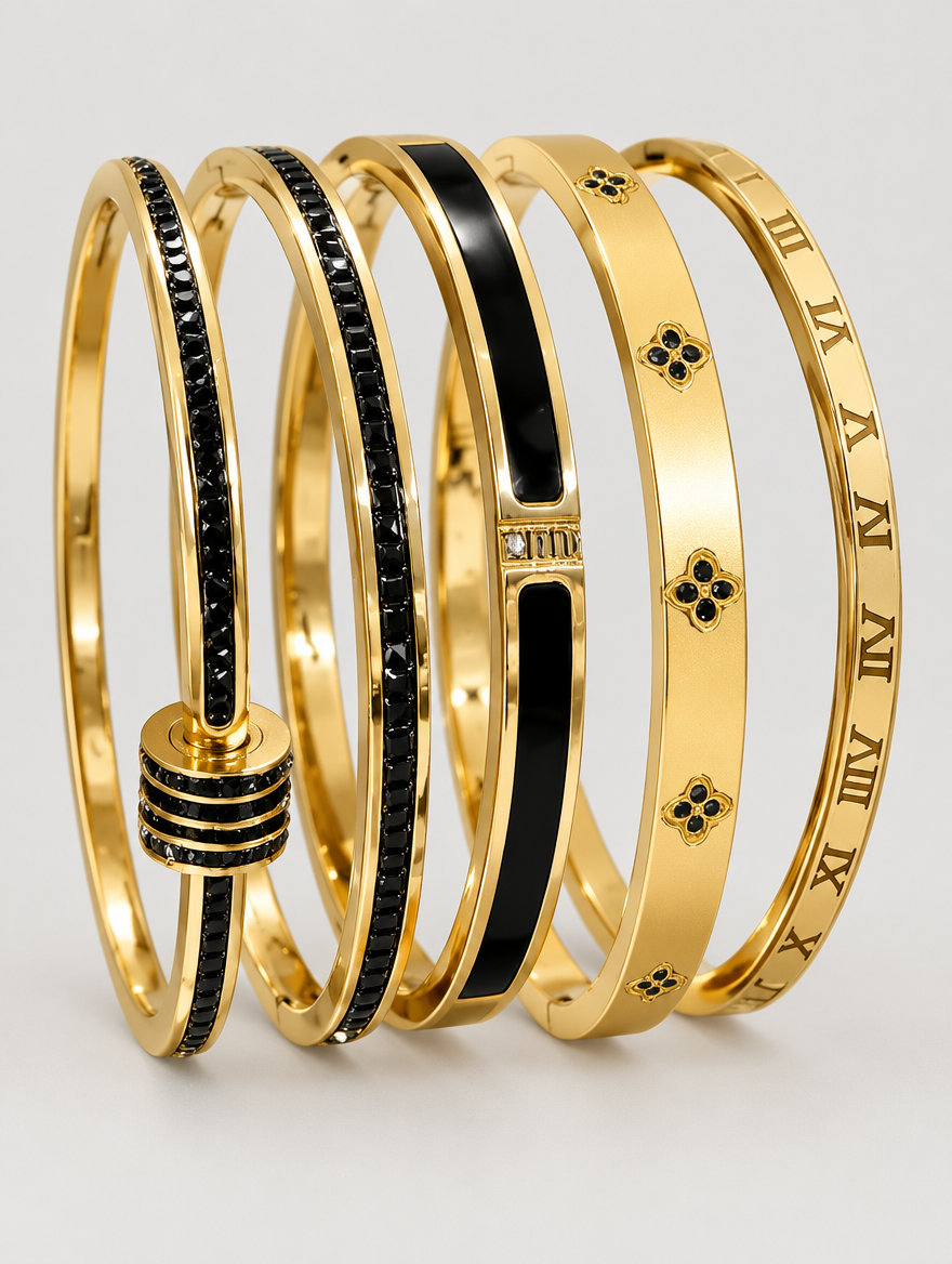 Set of five black and gold stackable bangle bracelets on a neutral background