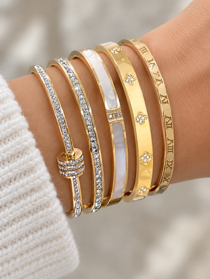 Woman wearing a stack of five gold bangles