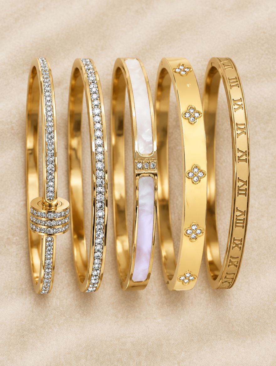 Five gold bangles laid out on cream velvet