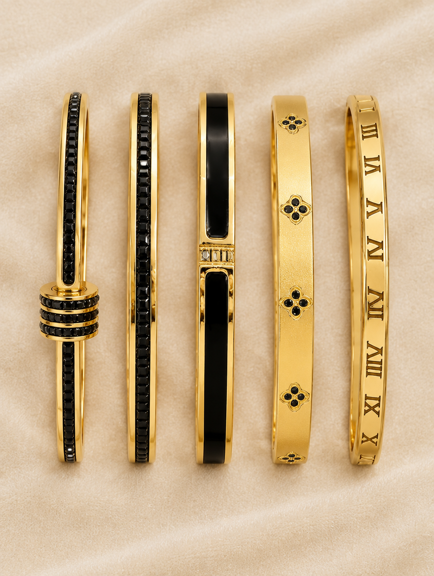 Black and gold bangles laid out on cream velvet