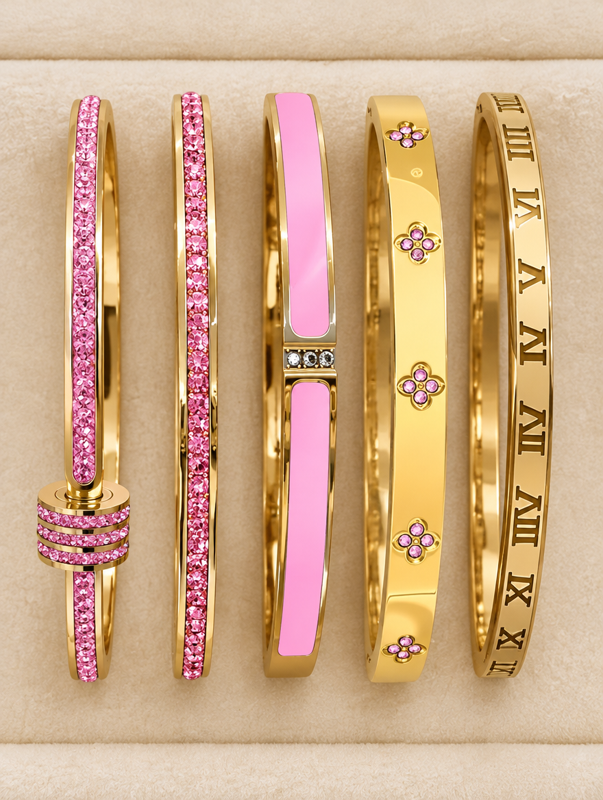 Five pink and gold bangles laid out on cream velvet
