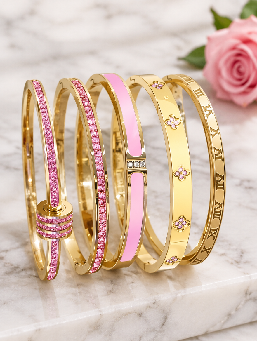 Five pink and gold bangles beside a pink rose on marble