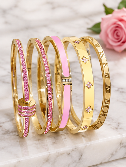 Five pink and gold bangles beside a pink rose on marble