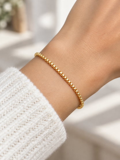 Woman wearing a gold box chain bracelet
