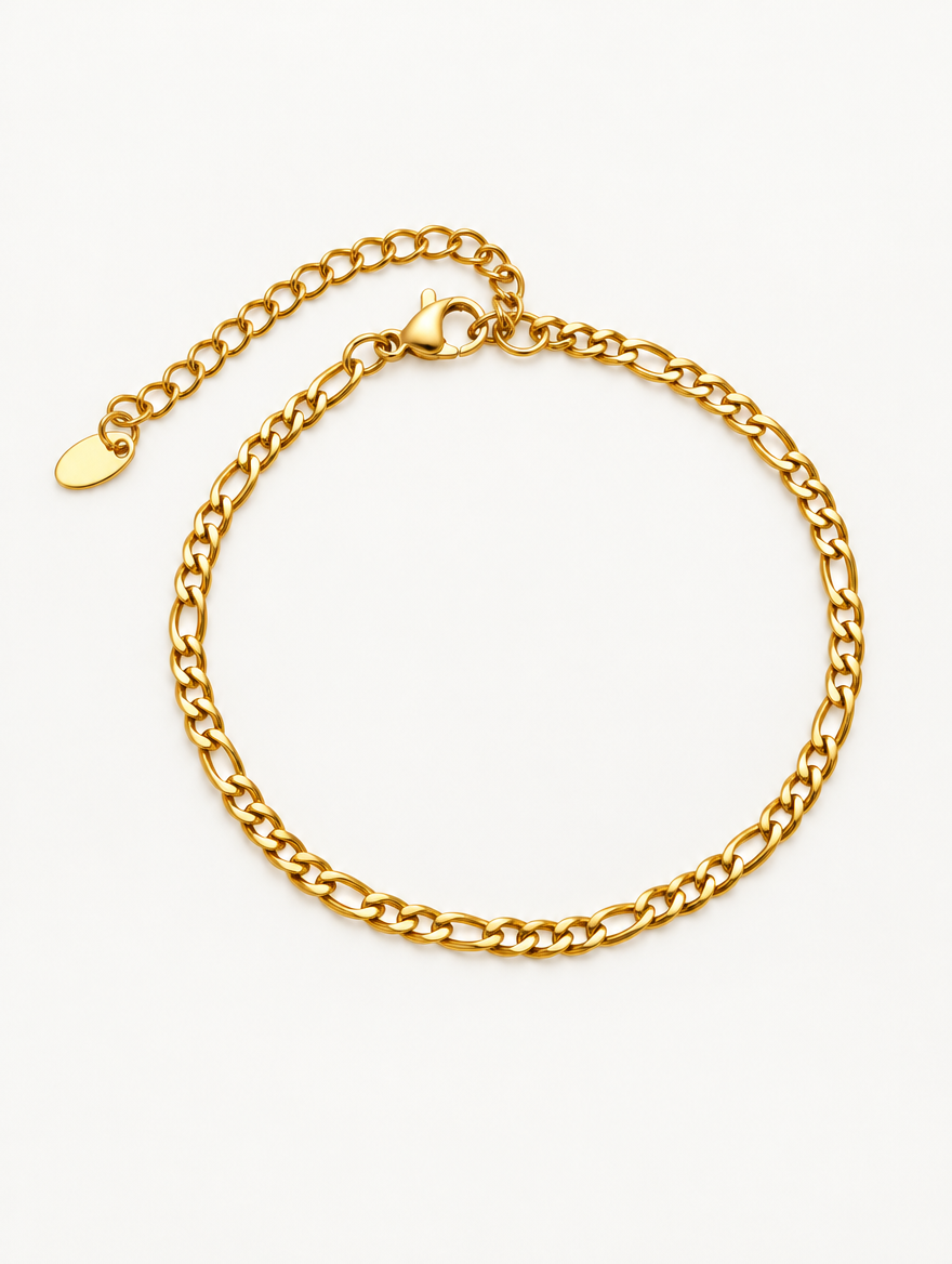 Gold figaro chain bracelet on a neutral background