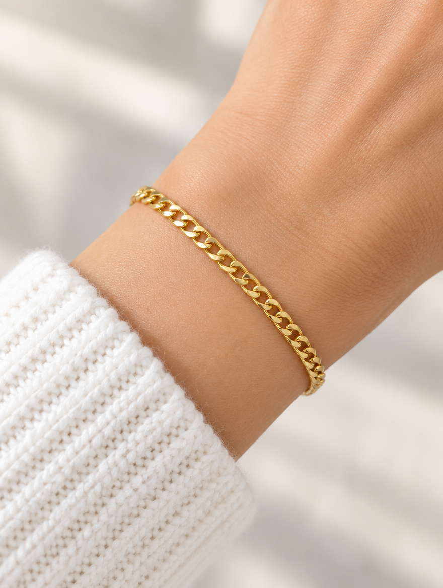 Woman wearing a gold figaro chain bracelet