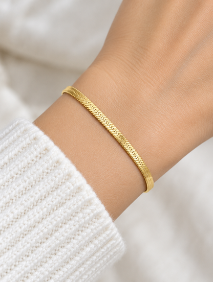 Woman wearing a gold herringbone chain bracelet