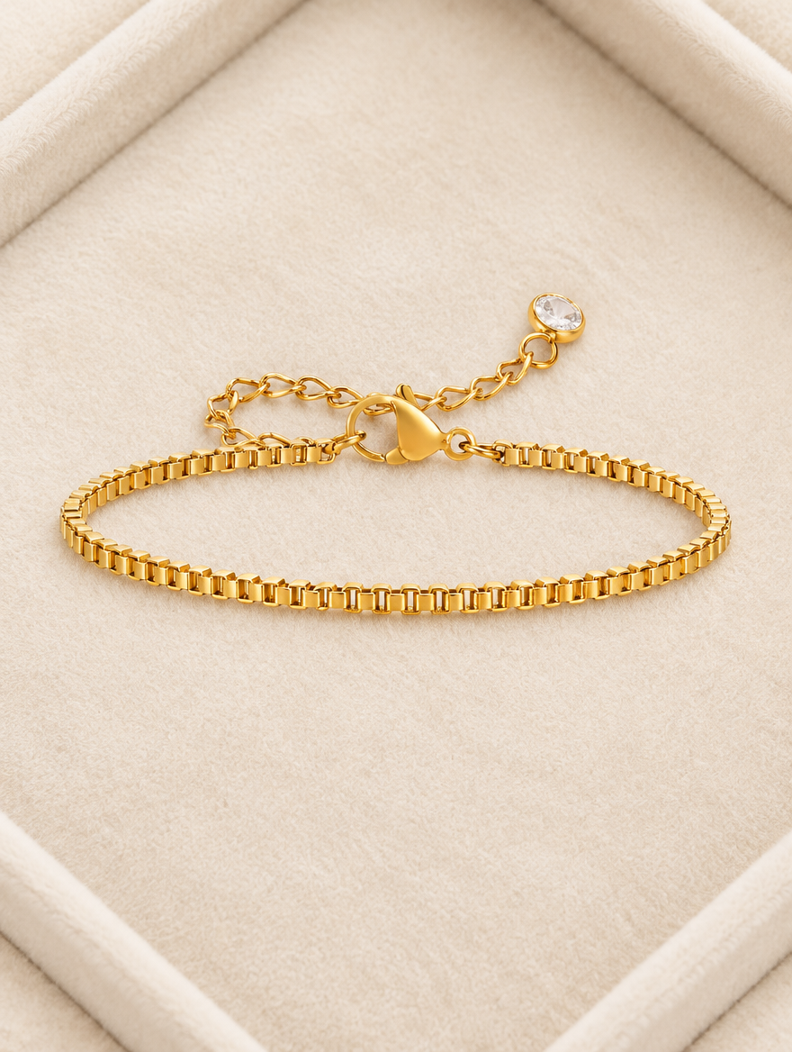 Gold box chain bracelet on cream velvet