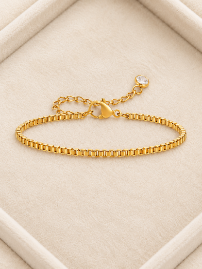 Gold box chain bracelet on cream velvet