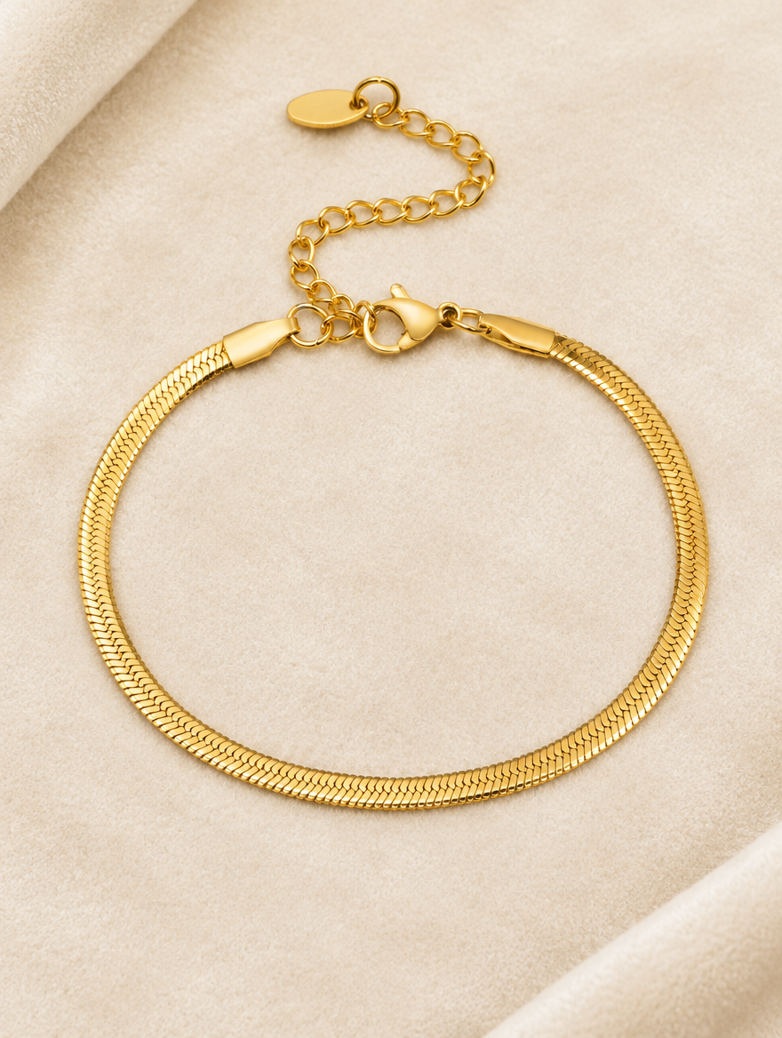 Gold herringbone chain bracelet on cream velvet