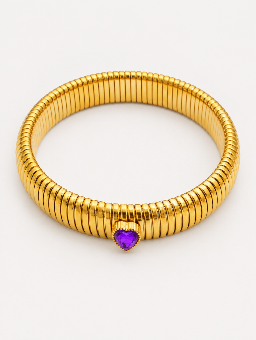 Gold wide ribbed stretch bracelet with a purple heart gem on a neutral background